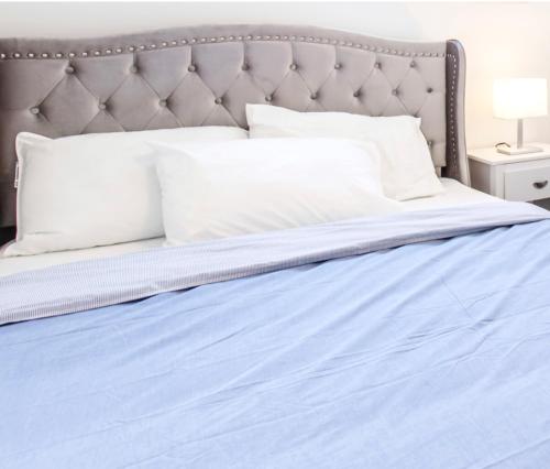 尼亚加拉瀑布New Luxury Suite 6Mins To Falls, Free Parking的一张带蓝色床单和白色枕头的床