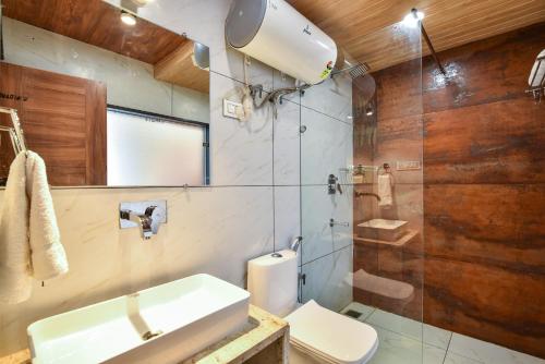 麦罗肯机Hotel Pawan Regency Mcleodganj的浴室配有卫生间、盥洗盆和淋浴。