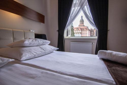 瓦乌布日赫城堡酒店的一间卧室设有一张大床和窗户