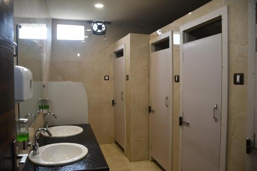加雅Vatika Banquet And Lawn的浴室设有2个水槽和2扇白色门
