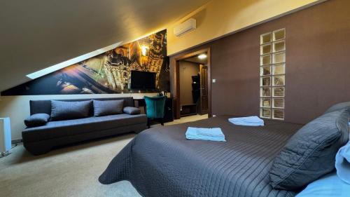 科希策Penzion Villa Regia的一间卧室配有一张床和一张沙发