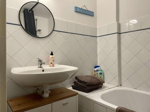 诺亚芒提亚Appartement Noirmoutier-en-l'Île, 1 pièce, 2 personnes - FR-1-224B-146的一间带水槽、浴缸和镜子的浴室
