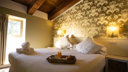 圣马丁德巴尔代格莱西亚斯拉克拉赛拉庄园酒店的一间卧室配有一张床,上面放着一个食物托盘
