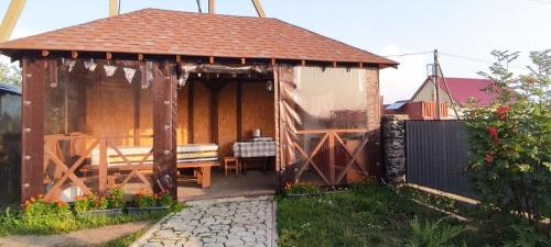 博罗沃耶Гостевой дом Jasmine的庭院内带长凳的木制凉亭