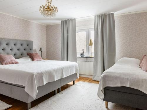 乌洛夫斯特伦Holiday Home Skjutsmåla - B的一间卧室配有两张床和吊灯。