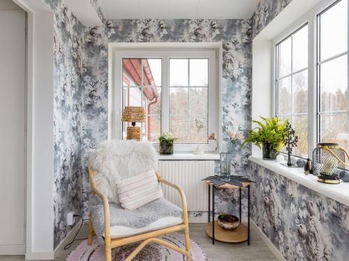 乌洛夫斯特伦Holiday Home Skjutsmåla - B的花卉壁纸房内的椅子