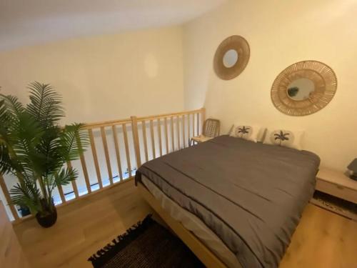 滨海雅尔Appartement au Parc de la Grange的一间卧室,里面装有床和植物