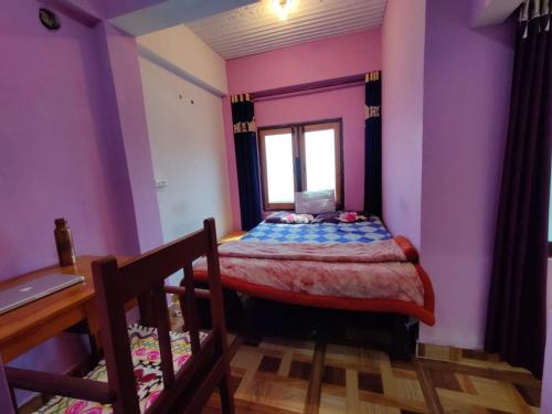 阿尔莫拉Bhanu Village House的一间卧室配有一张床、一张书桌和一个窗户。