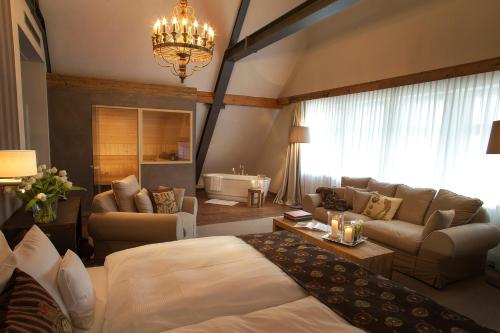 布兰肯海恩Spa & GolfResort Weimarer Land的一间卧室设有一张床和一间客厅。