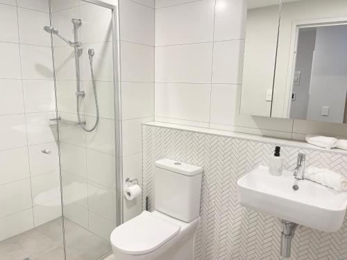 TuggeranongBlackdiamond 504 - Beautiful, modern apartment - 2BdR, 2BthR的浴室配有卫生间、盥洗盆和淋浴。
