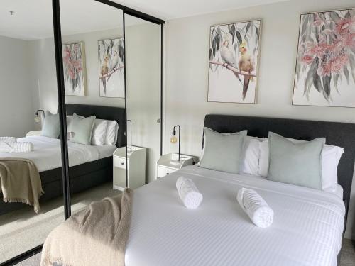 TuggeranongBlackdiamond 504 - Beautiful, modern apartment - 2BdR, 2BthR的一间卧室配有两张床和镜子