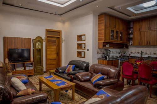 基加利Simaza Villa的一间带皮革家具的客厅和一间厨房
