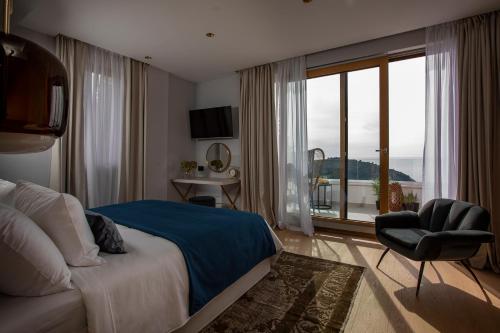 杜布罗夫尼克Dubrovnik luxury apartments的卧室配有床、椅子和窗户。