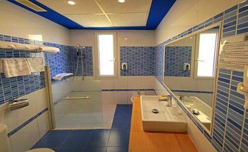 萨拉戈萨巴黎中心酒店的蓝色和白色的浴室设有水槽和淋浴