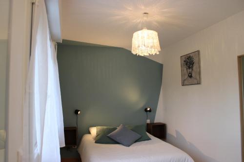 Faverolles-sur-CherLe Petit Saule - Gîte entre Beauval et Chenonceau的一间卧室配有一张床和一个吊灯