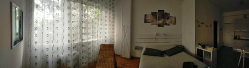 博洛尼亚Monolocale Fiera的客厅配有白色窗帘和沙发