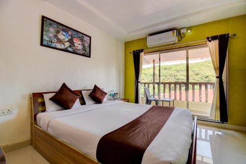 马哈巴莱斯赫瓦尔The Greenpark Retreat, Mahabaleshwar的一间卧室设有一张大床和一个窗户。