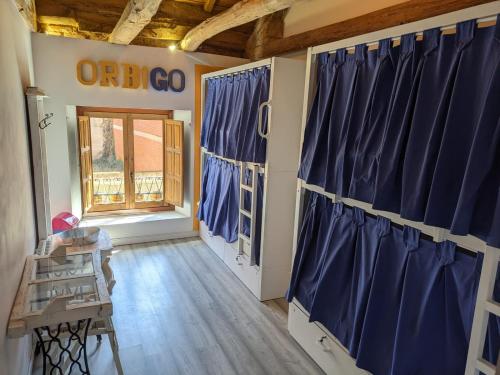 奥斯皮塔尔德奥尔维戈Albergue Casa de los Hidalgos - Sólo para Peregrinos的一间设有蓝色窗帘和窗户的客房