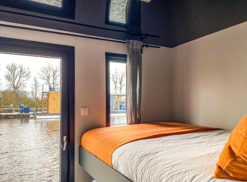 OffingawierHouseboat orange Sneekermeer的一间卧室设有一张床和一个窗口