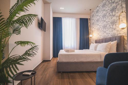 雅典Downtown Suites by Athens Tower Hotel的酒店客房,配有床和植物