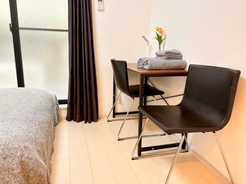 东京IXO Ts1的一间卧室配有书桌、椅子和床