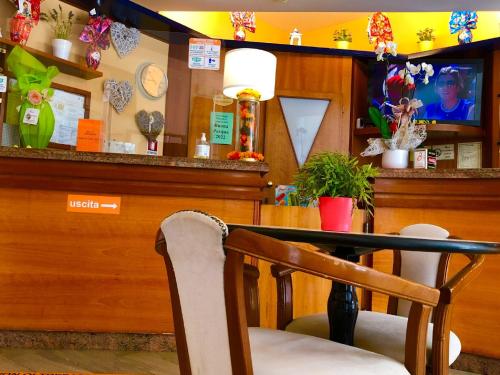 里米尼Hotel Alessi** Rimini的一间带桌子和酒吧的用餐室