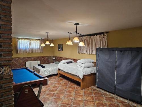 迪拉尔Apto-en el Bajo de la casa-estilo rústico en Dílar的带两张床和台球桌的客房