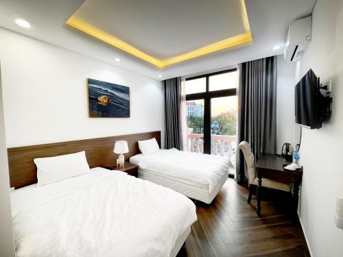 富国Legacy Phú Quốc的酒店客房设有两张床和电视。