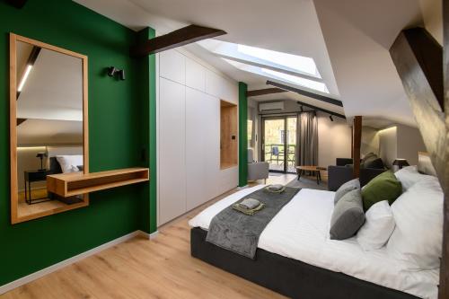埃格尔Várvédőház Apartmanok Eger的一间卧室设有一张大床和绿色的墙壁