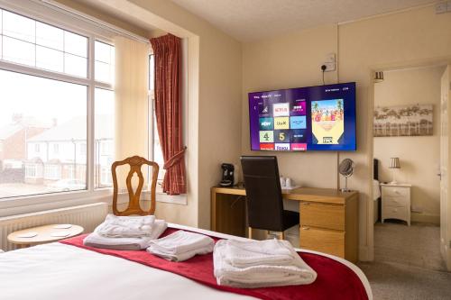 斯凯格内斯The Kildare的一间卧室配有一张床、一张书桌和一台电视。