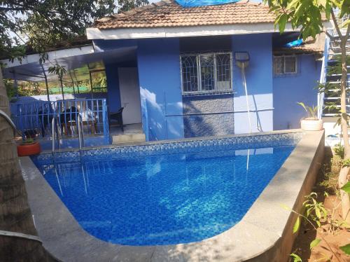 罗纳瓦拉Blue Lagoon 2bhk的蓝色房子前的游泳池