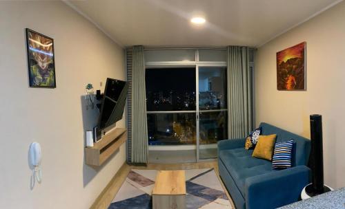 利马Mousse PL的客厅设有蓝色的沙发和窗户。