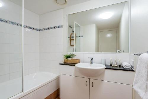 马库拉Beachfront Oasis with Private Rooftop Retreat的白色的浴室设有水槽、浴缸和镜子