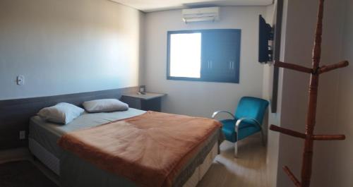 多拉杜斯Quarto Confortável Centro e perto de Hospital的一间小卧室,配有一张床和一把椅子