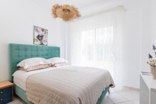 帕拉利亚狄奥尼索Apartment next to the Sea的一间卧室配有一张蓝色床头板的床