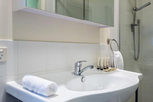 布里斯班Modern 2BR With Deck的白色的浴室设有水槽和镜子