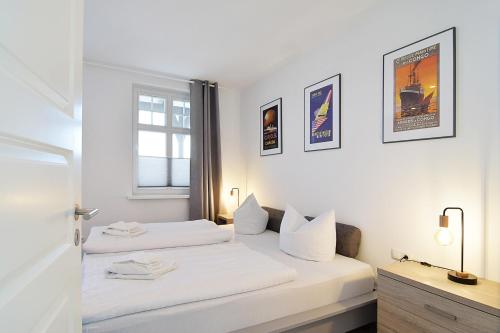 塞巴特阿尔贝克Haus Ahlbeck的配有2张床的白色墙壁和窗户。