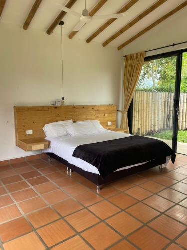 卡拉尔卡Ecohotel Alma的一间卧室配有一张大床和木制床头板