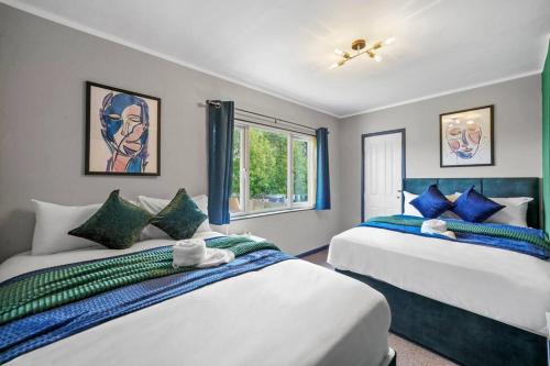 布里斯托Spacious Luxury Garden House Free Parking的一间卧室设有两张床和窗户。
