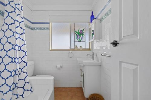 KarraganbahLake House Tuggerawong NSW的一间带水槽和卫生间的浴室以及窗户。