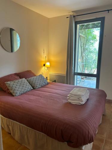 索马讷-德沃克吕兹Appartement Golf de Saumane 2 chambres 2 à 4 personnes的一间卧室配有一张带红色床单的床和一扇窗户。