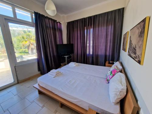卡洛吉亚Kalogria Beach Apartments的卧室设有一张白色大床和一扇窗户。