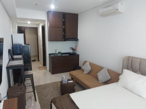 Klandasan KecilComfy Studio with City View @BorneoBay Residence的一间带床和沙发的房间和一间厨房