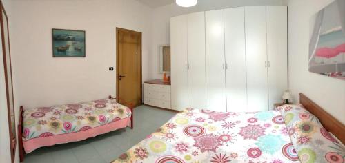 加利波利La Spiaggia sotto Casa的一间卧室配有两张床和白色橱柜
