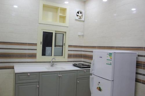 吉达دار الكيان للشقق المخدومة - Dar Al Kayan Serviced Apartments的厨房配有水槽和白色冰箱