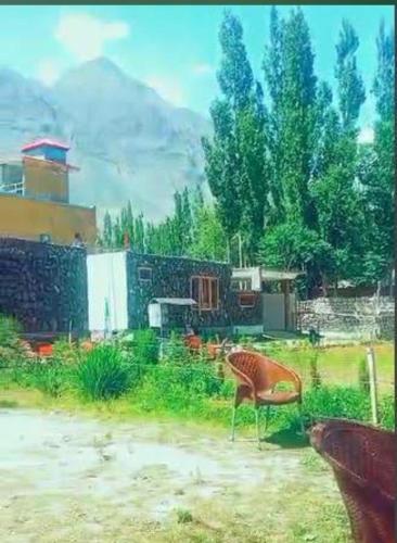 锡卡都Baltistan Sarayee hotel £ Guest House的坐在院子里的草地上的椅子