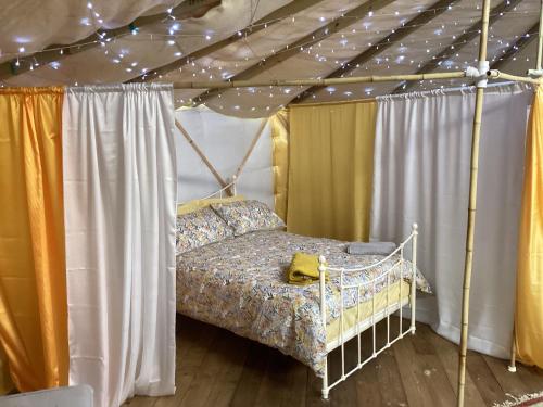 鲁特姆Vigo Retreat Yurt的一间帐篷内带天蓬床的卧室