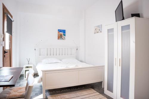 费拉Fira Central Budget Room and Kitchen的白色的卧室配有白色的床和一张桌子