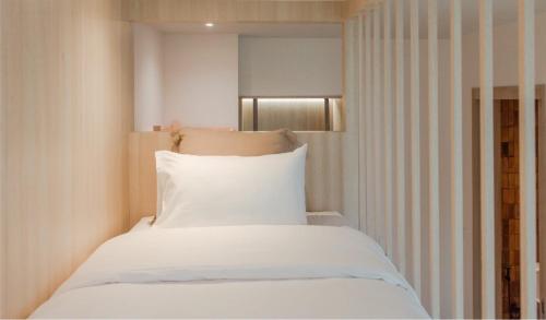 呵叻Punn Hotel Korat的一间卧室配有一张带白色床单的床和一扇窗户。