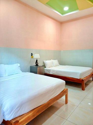 Ấp Phú LợiNGUYỆT MINH HOTEL的配有两张床铺的粉红色墙壁